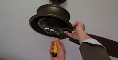 Electrician installing ceiling fan mounting bracket and fixture in Orange, CA