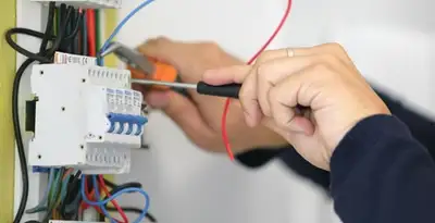 Electrician installing and adjusting circuit breakers in an electrical panel in Orange, CA