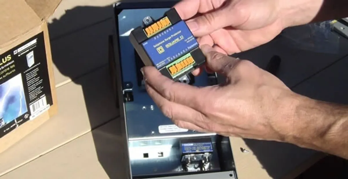 Electrician installing whole home surge protection unit inside main electrical panel in Orange, CA