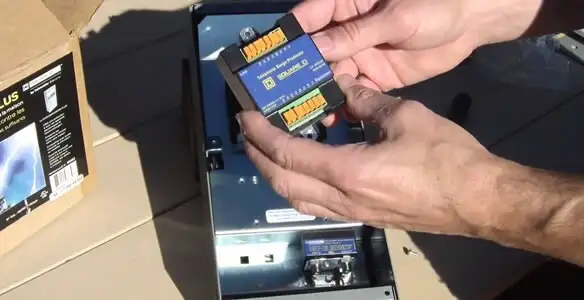 Electrician installing whole home surge protection unit inside main electrical panel in Orange, CA