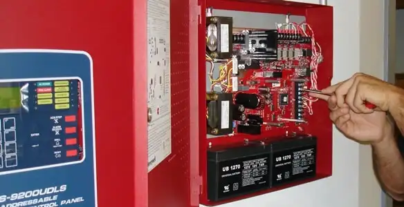 fire alarm installation service showing technician configuring fire alarm control panel in Orange, CA