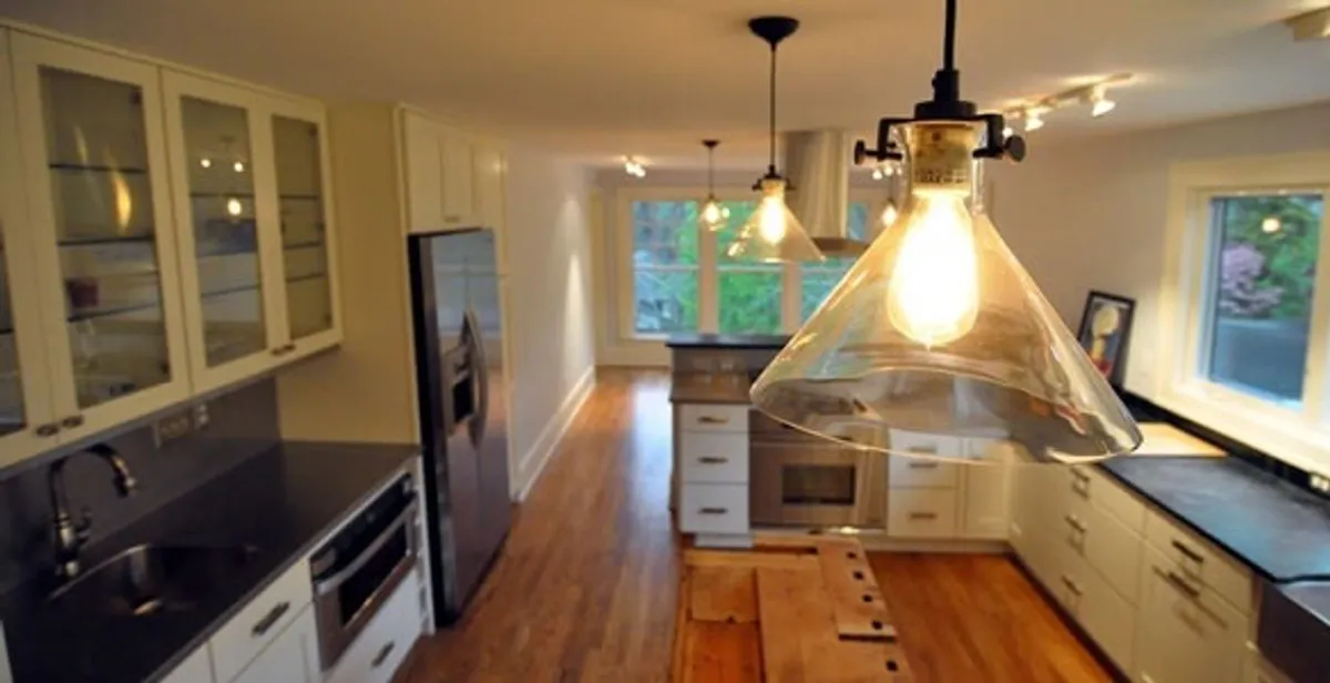 Residential electrician installing modern indoor light fixture in a home in Orange, CA