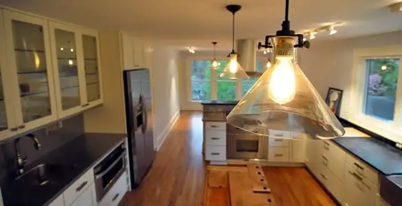 Residential electrician installing modern indoor light fixture in a home in Orange, CA